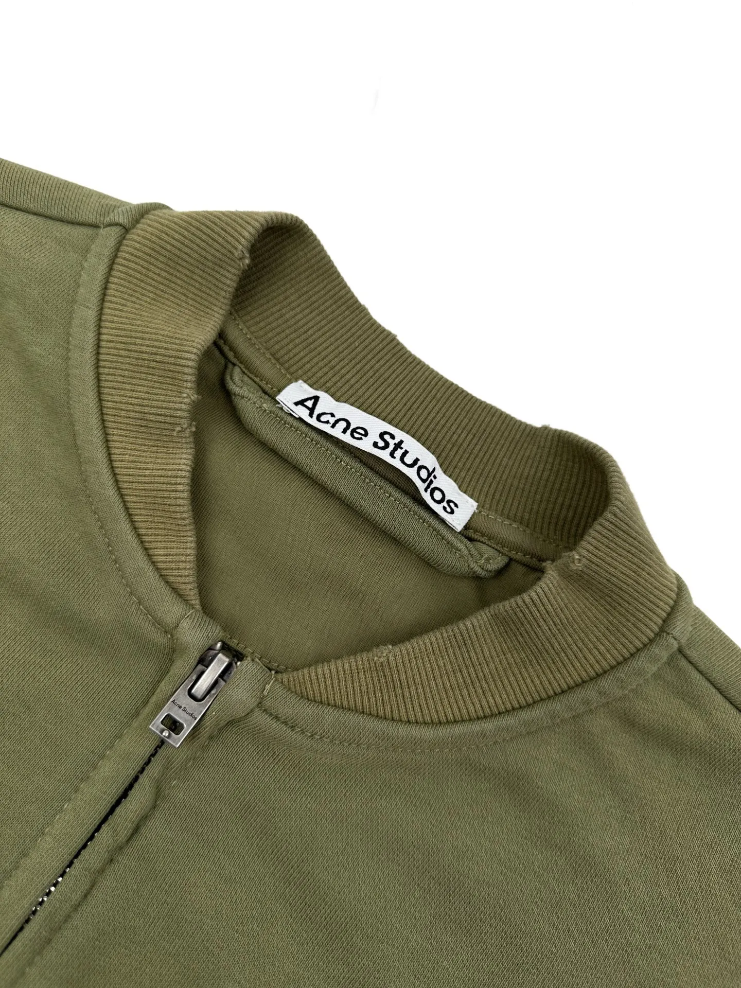 Acne Studios spray-painted distressed logo baseball collar jacket, custom-ordered soft velvet fleece cotton, crisp and smooth, skin-friendly and soft, olive green like mist between pine trees, matte matte surface flowing with warm and luxurious light, showing high-end restrained texture. Classic baseball collar zipper jacket has a neat and elegant silhouette, dropped shoulder tailoring for stretch and casualness, densely woven ribbing to show craftsmanship details, Acne Studios logo printing on the chest, engraving the brand heritage with Retro sports aesthetics Unobtrusive yet recognizable, it combines the Nordic minimalist style with the Retro sports style. It is low-key and elegant, with its own aura. Process 1: Using glue printing technology. The chest printing has been modified three times with the film screen. Use glue liquid paint to print the pattern on the fabric. Bake the fabric to fix the printed pattern. Technique 2: Gradient distressed spray-on process. By spraying dyes of different colors on the surface of the fabric, the clothes can show rich color changes under different lights and increase the visual layering. Process 3: Many parts of the body of the garment are worn by pure manual regular positioning and manual brushing. Texture and depth are added to the surface of the clothing to imitate the texture of natural wear. Process 4: The fabrics are fermented and washed for a better hand feel. Not easy to deform, not easy to shrink, not easy to fade, and maintain long-term beauty. Accessories: Customized 1:1 Acne zipper Customized 1:1 Acne trademark Version: Loose version Size: S M L XL Style number: CC